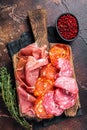Spanish meat tapas - salami, jamon, choriso cured sausages. Dark background. Top view Royalty Free Stock Photo