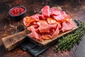 Spanish meat tapas - salami, jamon, choriso cured sausages. Dark background. Top view Royalty Free Stock Photo