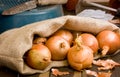 Spanish Onions in a hessian sack on rustic wooden.