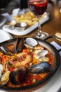 Spanish paella in a serving pan on a table in a cafe, close-up