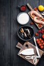 Spanish paella ingredients with rice, prawns, cuttlefish and mussel over black wooden table, top view with space for text Royalty Free Stock Photo