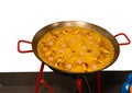 Spanish paella of meat, chicken and vegetables in a paella pan on a butane gas stove. copy space Royalty Free Stock Photo