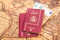 Spanish passport with euro bills inside, on a world map for travelers