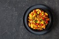 spanish potato salad with chorizo in black bowl