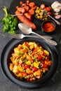 spanish potato salad with chorizo in black bowl Royalty Free Stock Photo