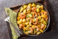 Spanish Potatoes roasted with Garlic Shrimp close-up in a plate. Horizontal top view