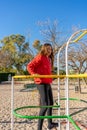 Spanish pre-adolescent girl fun climbing a metal structure to play in a park. Entertainment concept.