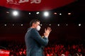 Spanish Prime Minister Pedro Sanchez is seen in a close up from below as he claps and greets the crowd as he enters the stage at t