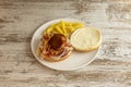 Spanish recipe for hamburger with beef covered with serrano ham with slices of cured cheese, crispy onion and portion of potatoes Royalty Free Stock Photo