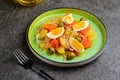 Spanish Remojon salad with boiled potatoes, blood orange, olives and boiled egg slices on a green ceramic plate on a dark concrete Royalty Free Stock Photo