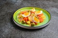 Spanish Remojon salad with boiled potatoes, blood orange, olives and boiled egg slices on a green ceramic plate on a dark concrete Royalty Free Stock Photo
