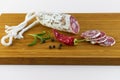 Spanish salami also sliced with dried red chili pepper and black pepper and rosemary on a wooden board Royalty Free Stock Photo