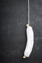 Spanish salchichon dry cured sausage on black background with space for text Royalty Free Stock Photo