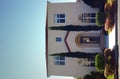 Spanish style home with tall trees at entrance Royalty Free Stock Photo