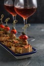 Spanish tapa pinxtos with tuna, peper, onion and oregano. Wine on background Royalty Free Stock Photo