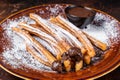 Spanish tapas churros with sugar and chocolate sauce. Dark background. Top view Royalty Free Stock Photo