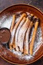 Spanish tapas churros with sugar and chocolate sauce. Dark background. Top view Royalty Free Stock Photo