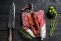 Spanish tapas sliced sausages salami, fuet and chorizo on a wooden cutting board. Black wooden background. Top view Royalty Free Stock Photo