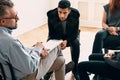 Spanish teenager listening to counselor during meeting of support group