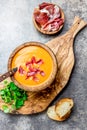 Spanish tomato soup Salmorejo served in olive wooden bowl with ham jamon serrano on stone background. Top view Royalty Free Stock Photo