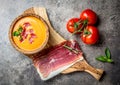 Spanish tomato soup Salmorejo served in olive wooden bowl with ham jamon serrano on stone background. Top view Royalty Free Stock Photo