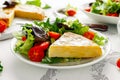 Spanish tortilla, omelette with potato, onion, vegetables, tomatoes, olives and herbs in a white plate. breakfast Royalty Free Stock Photo