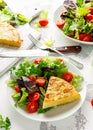 Spanish tortilla, omelette with potato, onion, vegetables, tomatoes, olives and herbs in a white plate. breakfast Royalty Free Stock Photo