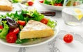 Spanish tortilla, omelette with potato, onion, vegetables, tomatoes, olives and herbs in a white plate. breakfast Royalty Free Stock Photo