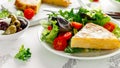 Spanish tortilla, omelette with potato, onion, vegetables, tomatoes, olives and herbs in a white plate. breakfast Royalty Free Stock Photo