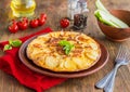 Spanish tortilla, traditional dish with eggs and fried potatoes on a clay plate on a wooden background. Potato recipes Royalty Free Stock Photo