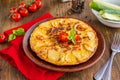 Spanish tortilla, traditional dish with eggs and fried potatoes on a clay plate on a wooden background. Potato recipes Royalty Free Stock Photo