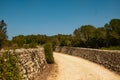Spanish unpaved street in the spanish countryside with stones sides. an old empty dirt road is seen on summer day with clear blue