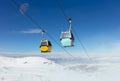 Two cable car cabins high above snowy mountains with the moon in the sky. Royalty Free Stock Photo