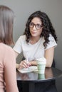 Spanish woman psychologist or business coach conducts a session with a client and takes notes in a notebook. formation, Royalty Free Stock Photo