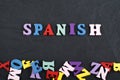 SPANISH word on black board background composed from colorful abc alphabet block wooden letters, copy space for ad text. Learning Royalty Free Stock Photo