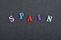 SPANISH word on black board background composed from colorful abc alphabet block wooden letters, copy space for ad text. Learning Royalty Free Stock Photo