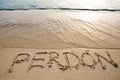 Spanish word perdÃÂ³n written in the sand