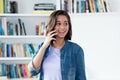 Spanish young adult woman laughing at phone