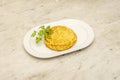 Spanish zucchini omelette garnished with parsley on a white marble table