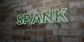 SPANK - Glowing Neon Sign on stonework wall - 3D rendered royalty free stock illustration