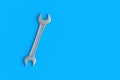 Spanner on blue background. Metal wrench in workshop. Repair and maintenance tool. Top view. Copy space. Royalty Free Stock Photo