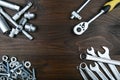 Spanners, socket wrenches, bolts and nuts on dark wooden surface