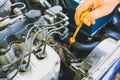 Spark plug in old car engine. Man checking oil level in the tank. Inner details of machine. Repairing of vehicle Royalty Free Stock Photo