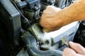 Spark plug in old car engine. Man checking oil level in the tank. Inner details of machine. Repairing of vehicle Royalty Free Stock Photo