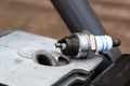 Spark plug unscrewed from the cylinder of the combustion chamber of a two-stroke engine. Replacement and malfunction of the