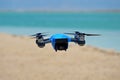The Spark quadrocopter drone in rubber protection is hovering in the air against the background of the sea. Royalty Free Stock Photo