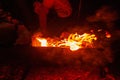 Sparking bonfire with tourist people sit around bright bonfire near camping tent in forest night background