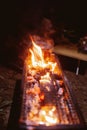 Sparking bonfire with tourist people sit around bright bonfire near camping tent in forest night background