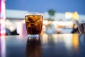 Sparking water soda or coca cola in the glass on the table with bokeh in the night