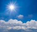 Sparkle sun above dense cumulus clouds on the blue sky background Royalty Free Stock Photo